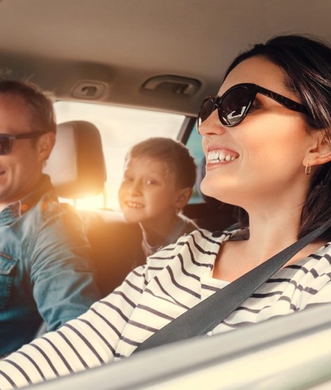 Family smiling inside car