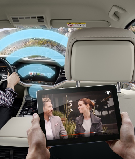 Children using a computer tablet and laughing in a car